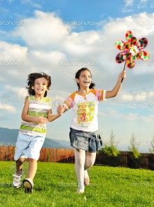 Fantastic scene of happy children running and playing carefreely on green meadow in nature